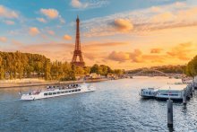 Tourist cruise ships with the Eiffel tower in the rays of the setting sun