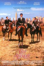3 men on horses in a open field with tall buildings behind them