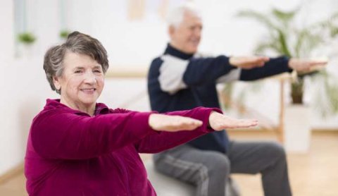 two senior with hands out exercising