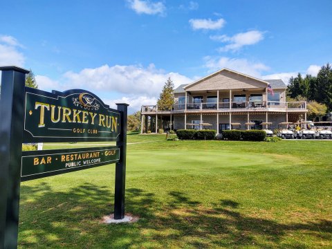 Turkey Run sign with grass and building in background