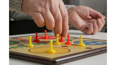a hand moving a game piece on a board game